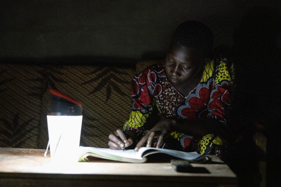 Woman in Uganda using a solar energy lamp